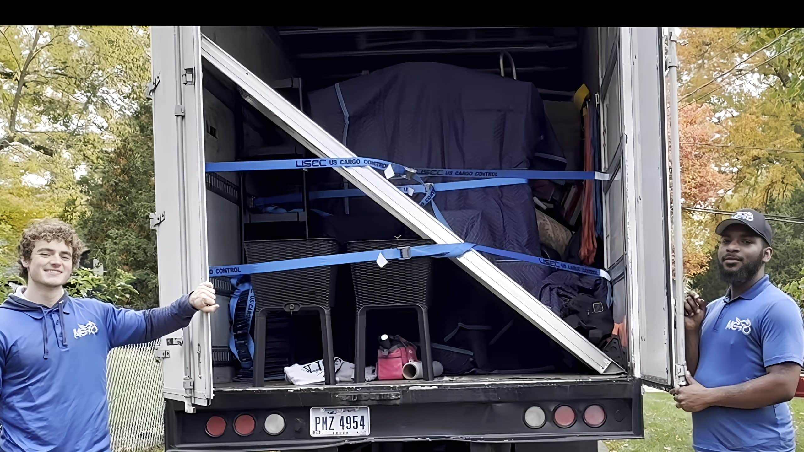 two movers standing with their loaded moving truck